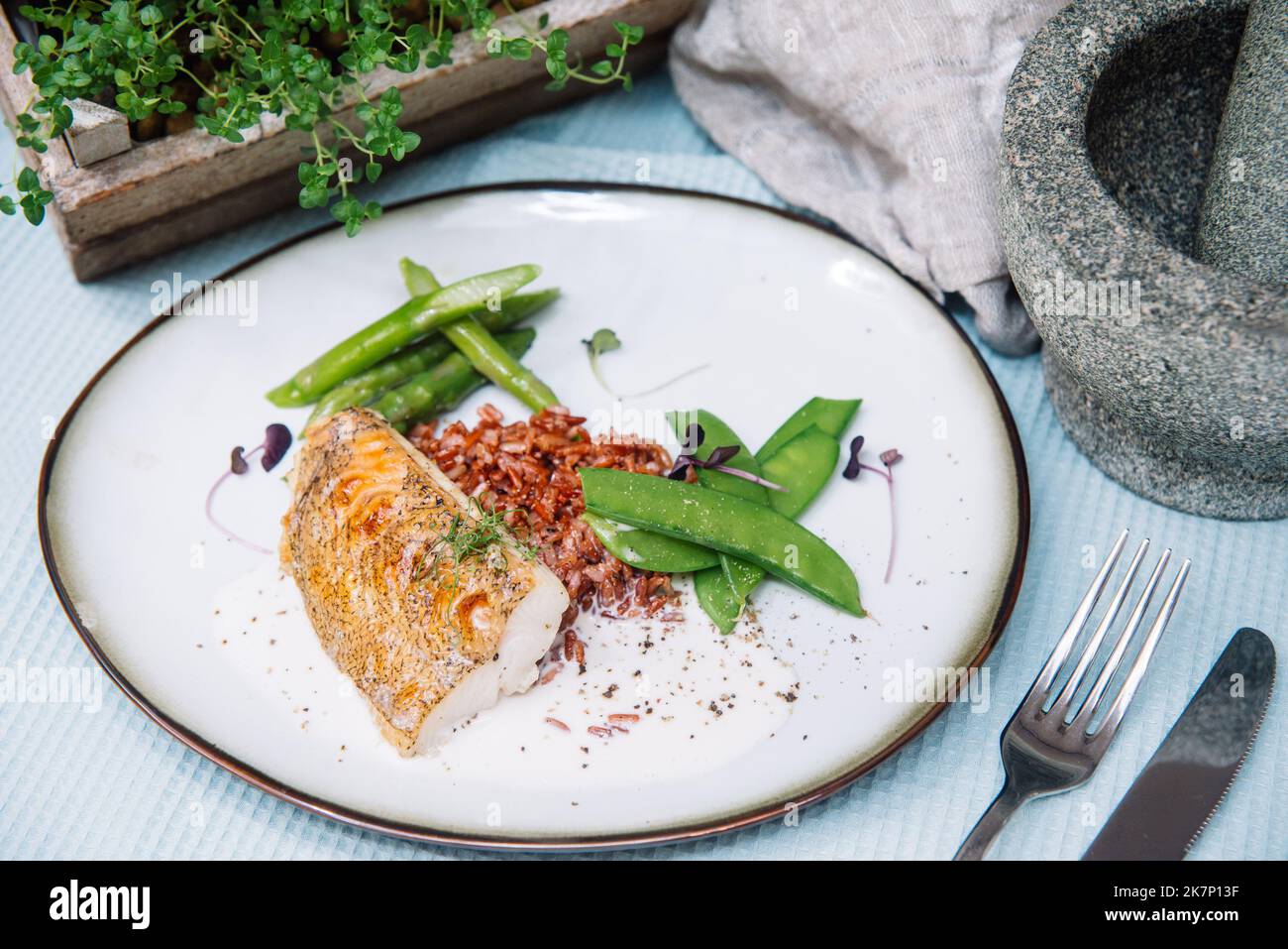 Halibut white fish fillet with ruby rice in coconut sauce and blanched