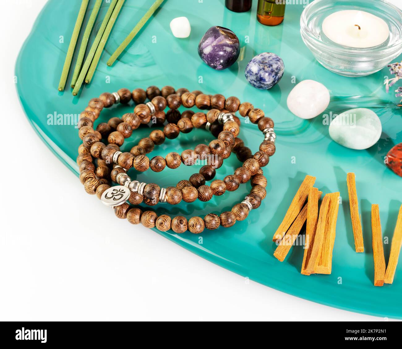 Rosary beads, aroma sticks, chakra stones, sandalwood sticks and candle Stock Photo