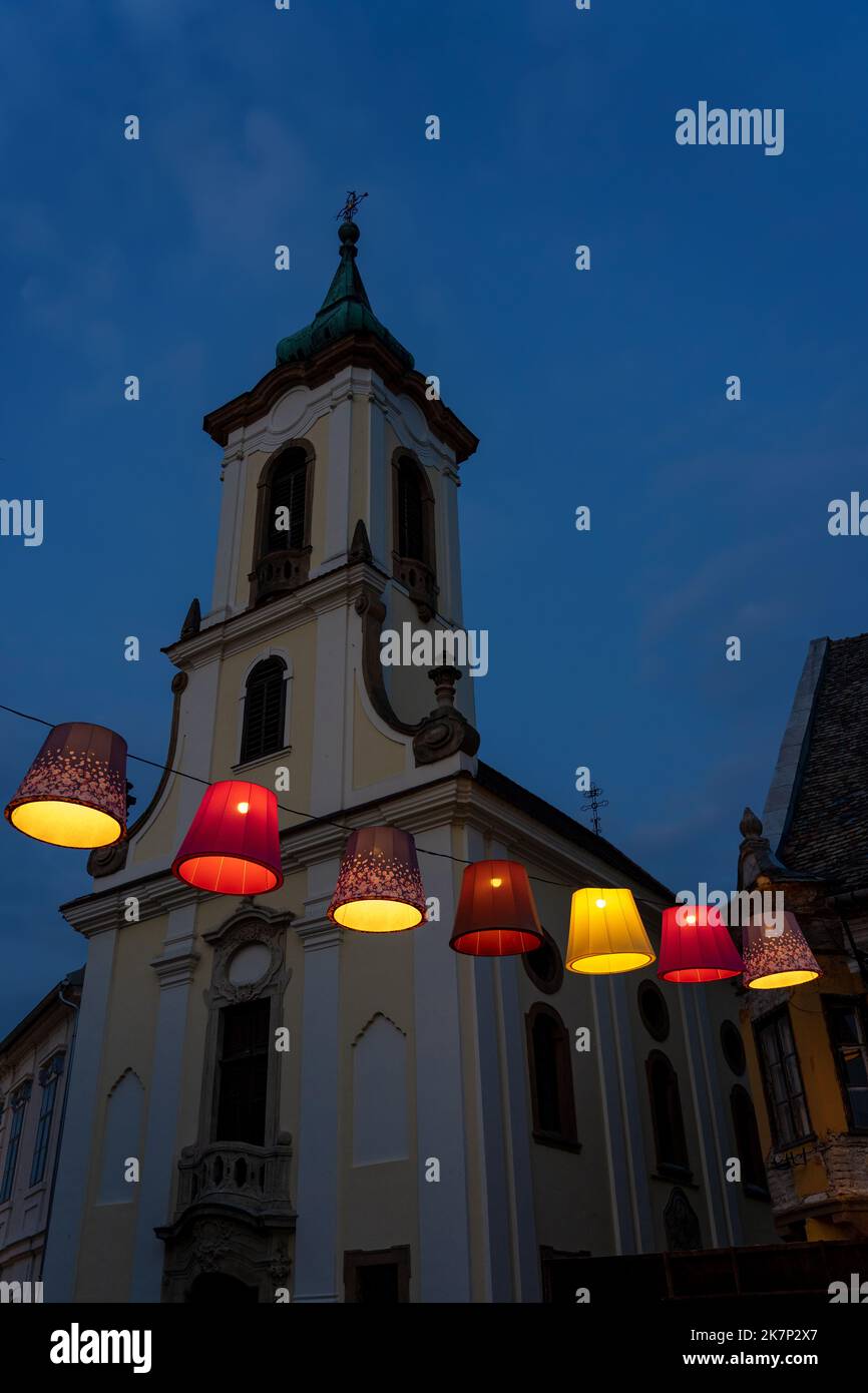 Main square with beautiful city lights in Szentendre Hungary next to Budapest with colorful banner light decorations and the Blagovestenska church Stock Photo