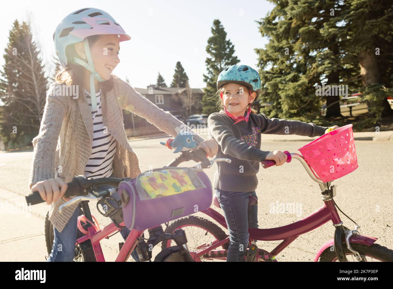 Cheerful sisters riding bicycle on walkway Stock Photo Alamy