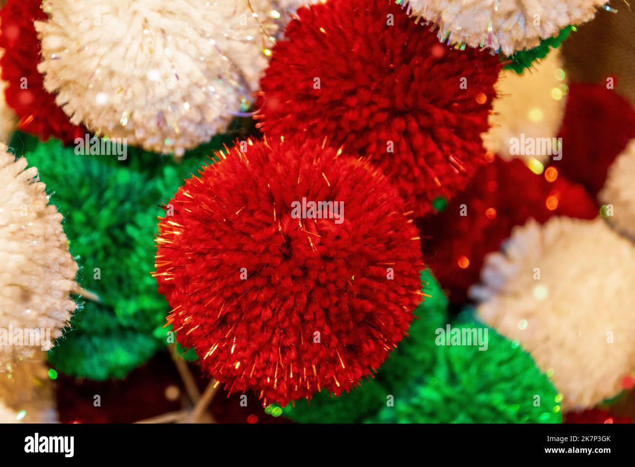 Pretty Festive Christmas Holiday background of Red Green and White sparkly pompom balls - some in focus and some blurred and boke Stock Photo