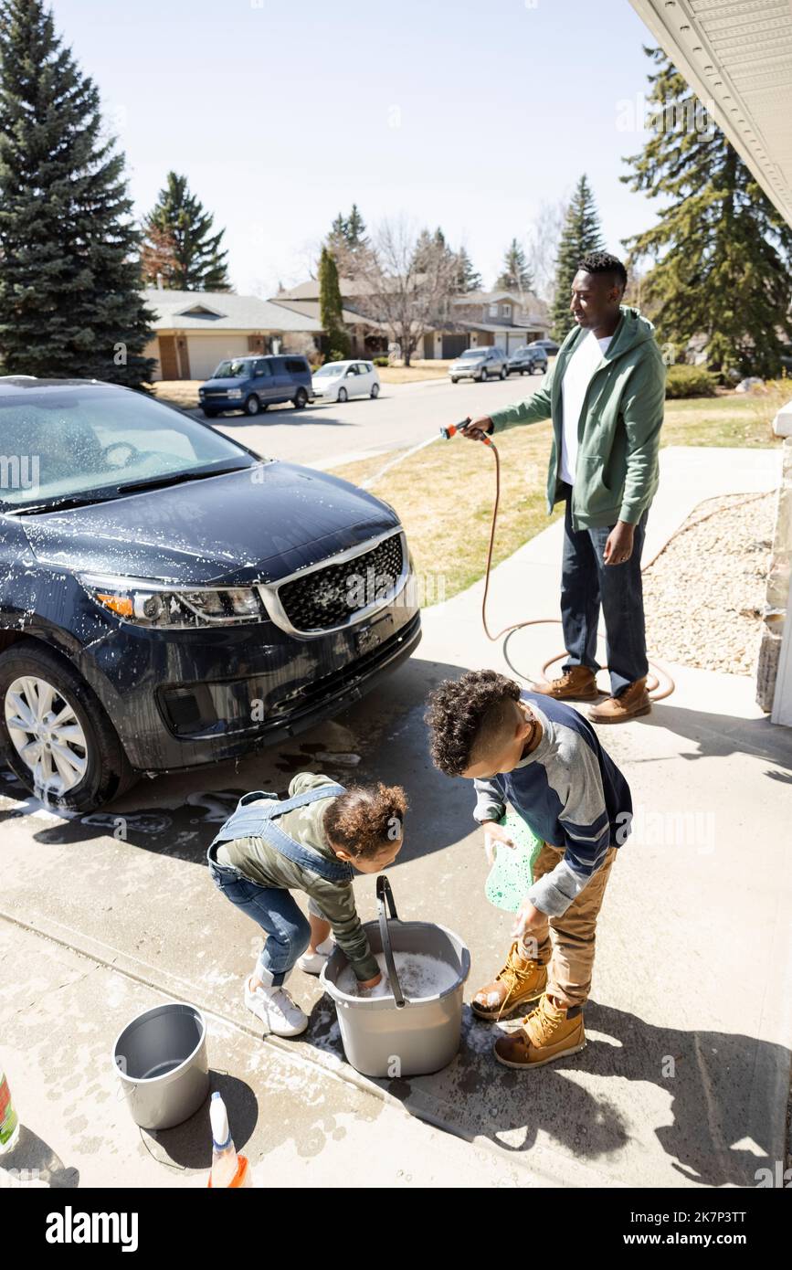 Father and children washing car in driveway Stock Photo Alamy