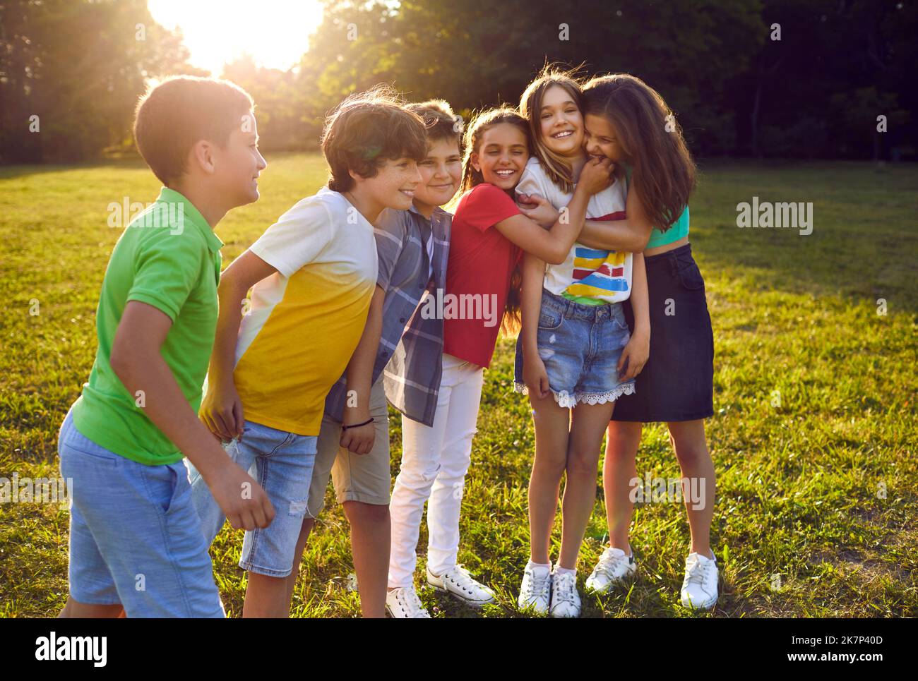 Friendly funny teen boys and girls in summer park have good time outdoors together with peers Stock Photo