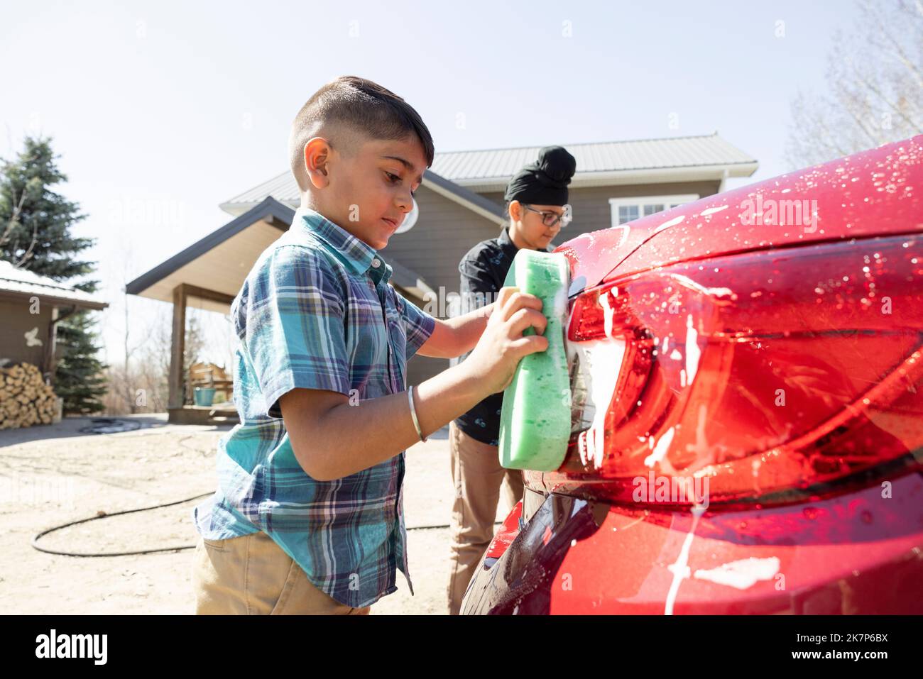 Boy washing car in driveway Stock Photo Alamy