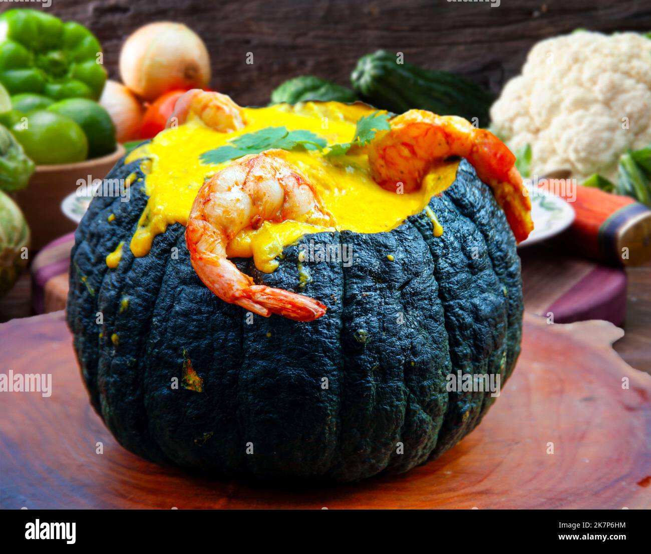 Prawns in Pumpkin (Camarao na Moranga) - Prawns with a creamy coconut milk sauce served inside a roasted pumpkin. Stock Photo