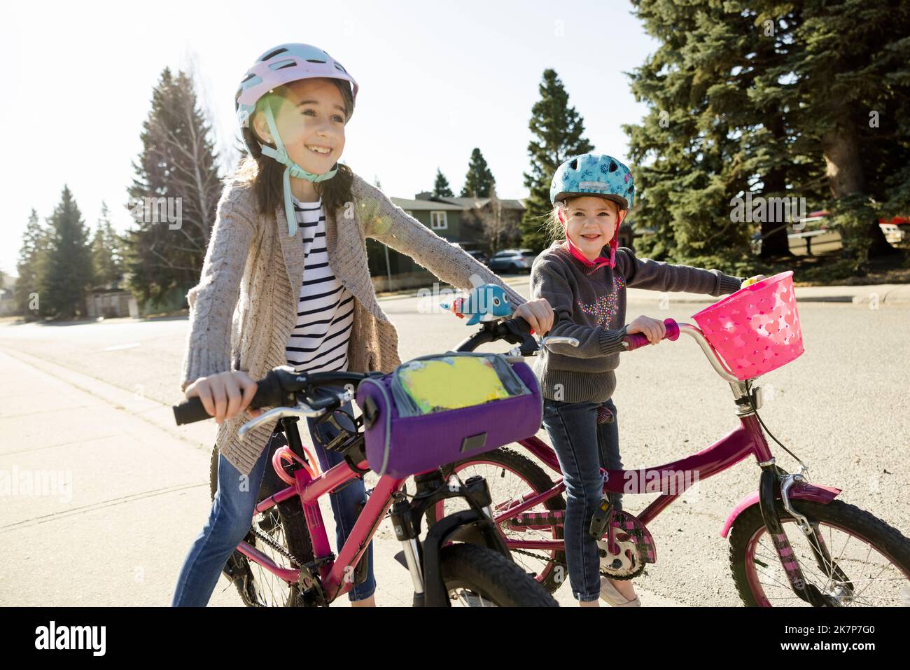 Cheerful sisters riding bicycle on walkway Stock Photo Alamy