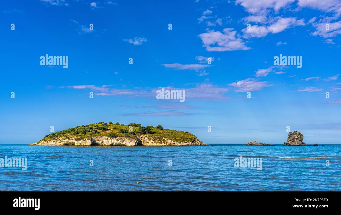 The islet and rock of Portonuovo, in the Gargano coast near the tourist town of Vieste seen from the sandy beach of Portonuovo, Vieste, Puglia Stock Photo