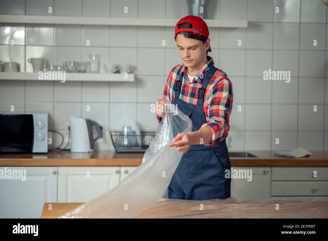 Experienced worker protecting the tabletop before painting Stock Photo