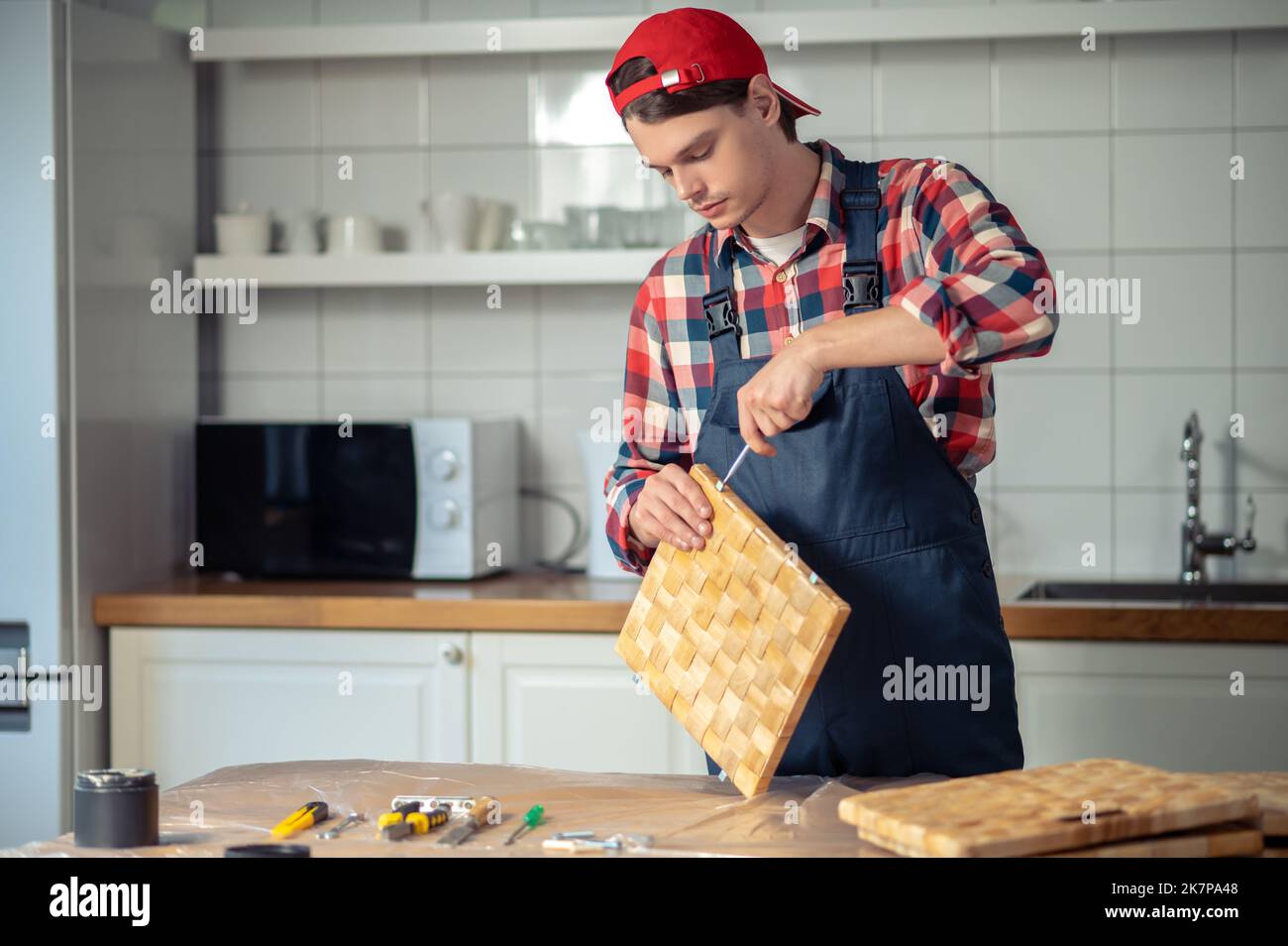 Concentrated carpenter making a straw box on the kitchen table Stock Photo
