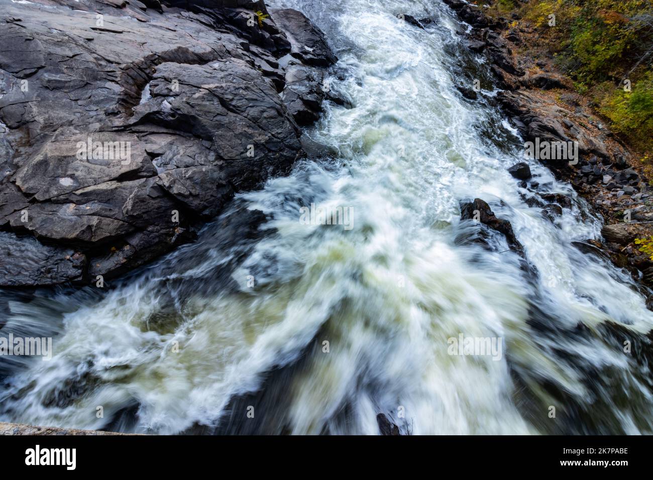 A view down the river of the  turbulent flow of water over bedrock; an action shot. Stock Photo