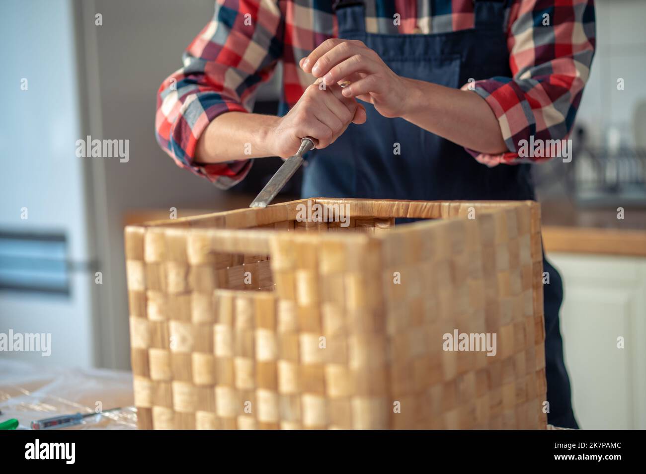 Carpenter removing the excess glue from the finished wood box Stock Photo