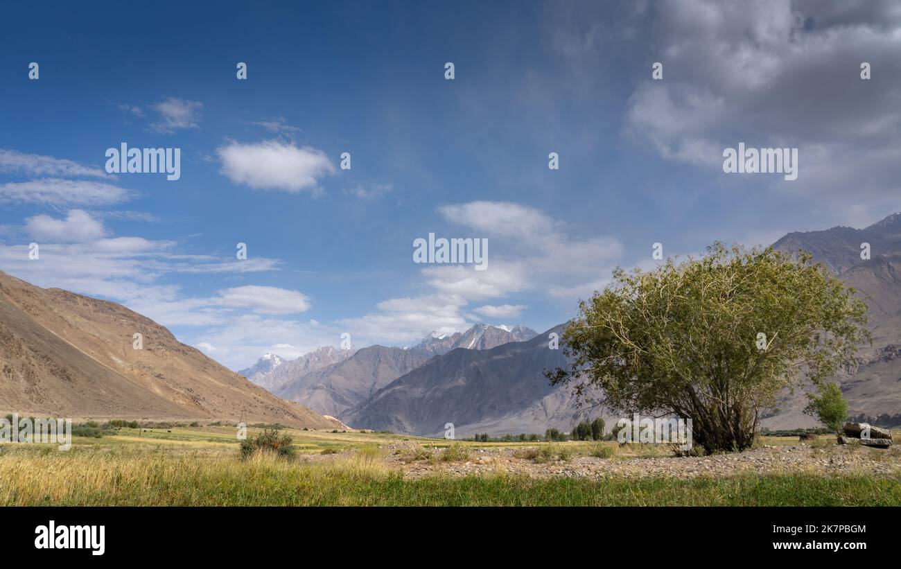 Panoramic view of the start of Wakhan Corridor with Hindu Kush mountain range in Afghanistan near Ishkashim, Gorno-Badakshan, Tajikistan Pamir Stock Photo