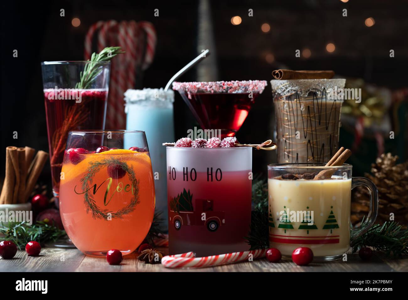 Front facing view of several Christmas cocktails against a festive dark background. Stock Photo