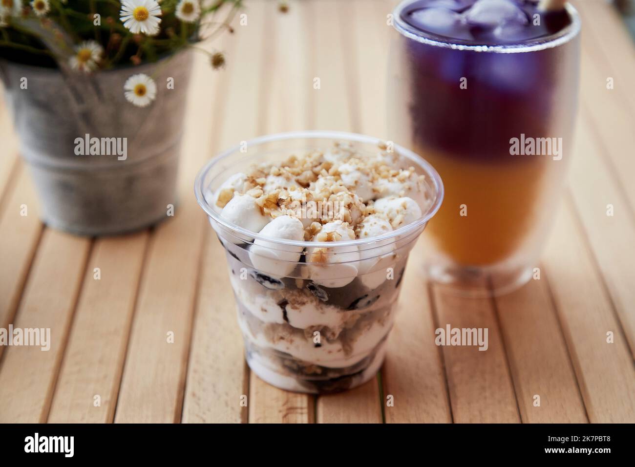 Purple and yellow cocktail with straw reed. Light natural dessert with ...