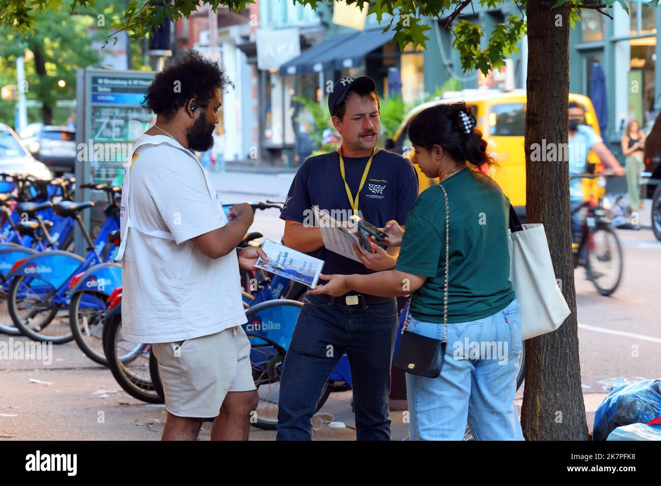 Street canvassers in New York canvassing for the charitable organization Humane Society soliciting info and donations from people on the sidewalk Stock Photo