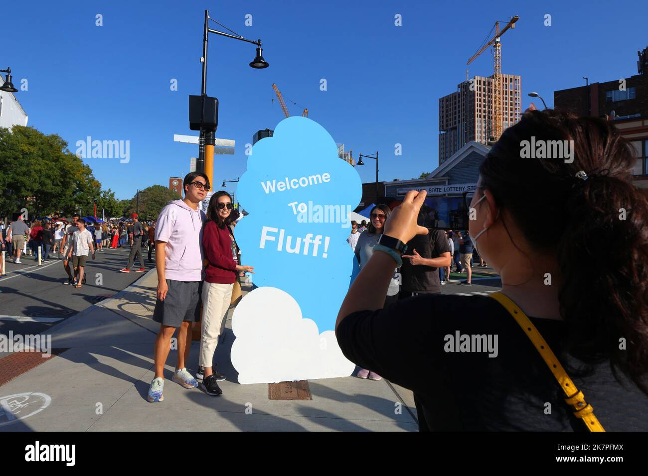 People pose for selfies with the Welcome to Fluff Festival signage in Union Square, Somerville, Massachusetts, September 17, 2022. Stock Photo
