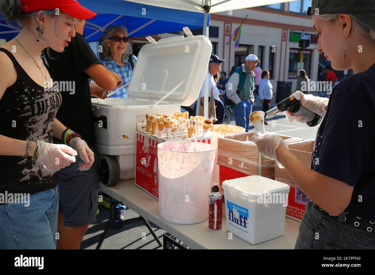 A worker from Gracie's Ice Cream toasts a marshmallow fluff dipped ice cream cone at the What The Fluff Festival in Somerville, Massachusetts Stock Photo