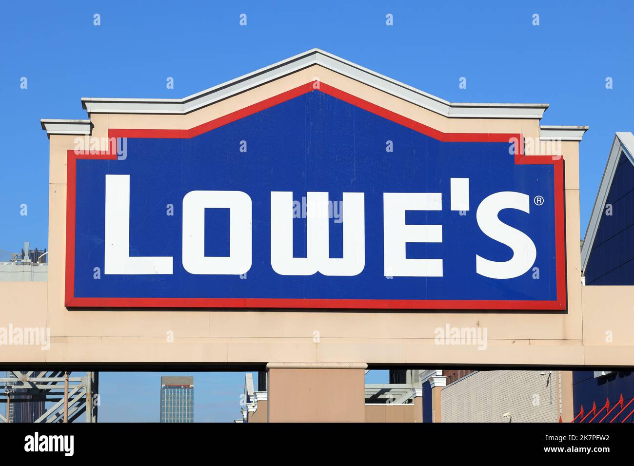 Logo and signage for Lowe's home improvement center set against a sunny blue sky. Stock Photo