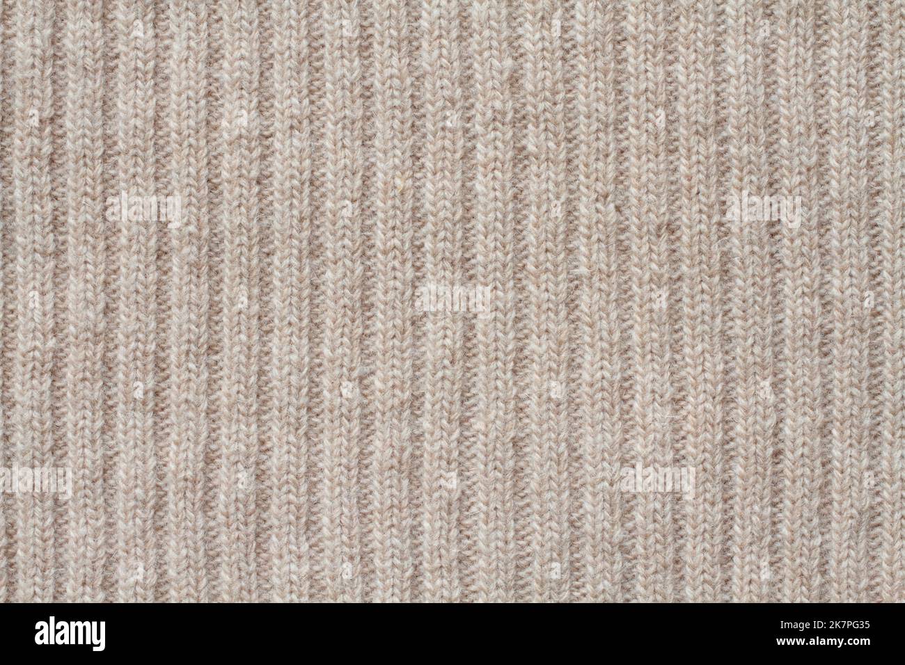 Light beige woolen knitted fabric texture. Macro. Stock Photo