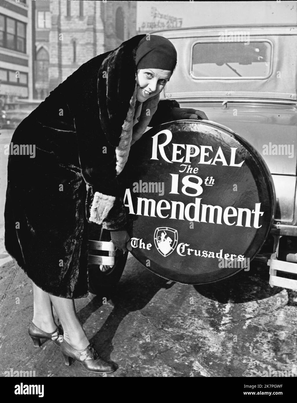 Prohibition. Miss Elizabeth Thompson was one of the first members of 'The Crusaders' national organization formed to overthrow prohibition, to put the new tire cover on her car. Miss Thompson with tire cover reading 'Repeal the 18th Amendment.' Stock Photo