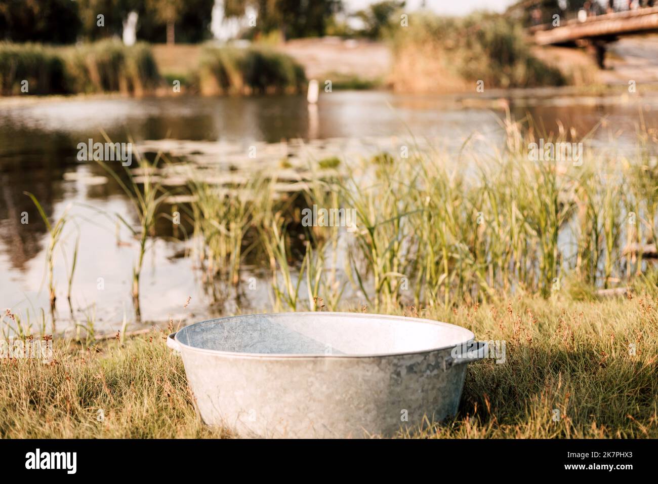 Metal basin near the lake on a sunny summer day Stock Photo