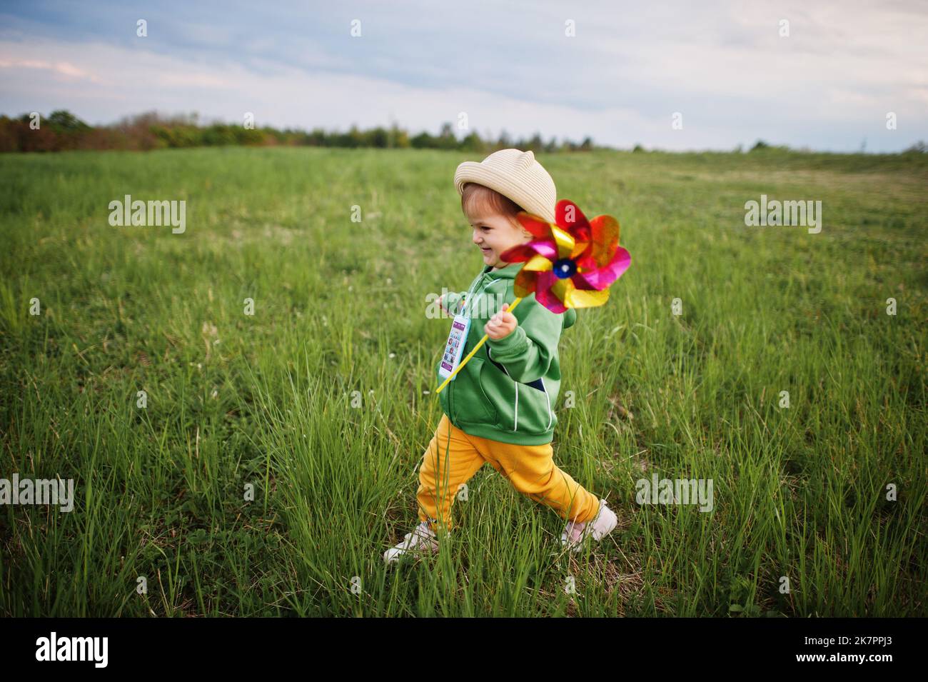 Babay girl with pinwheel at meadow Stock Photo - Alamy
