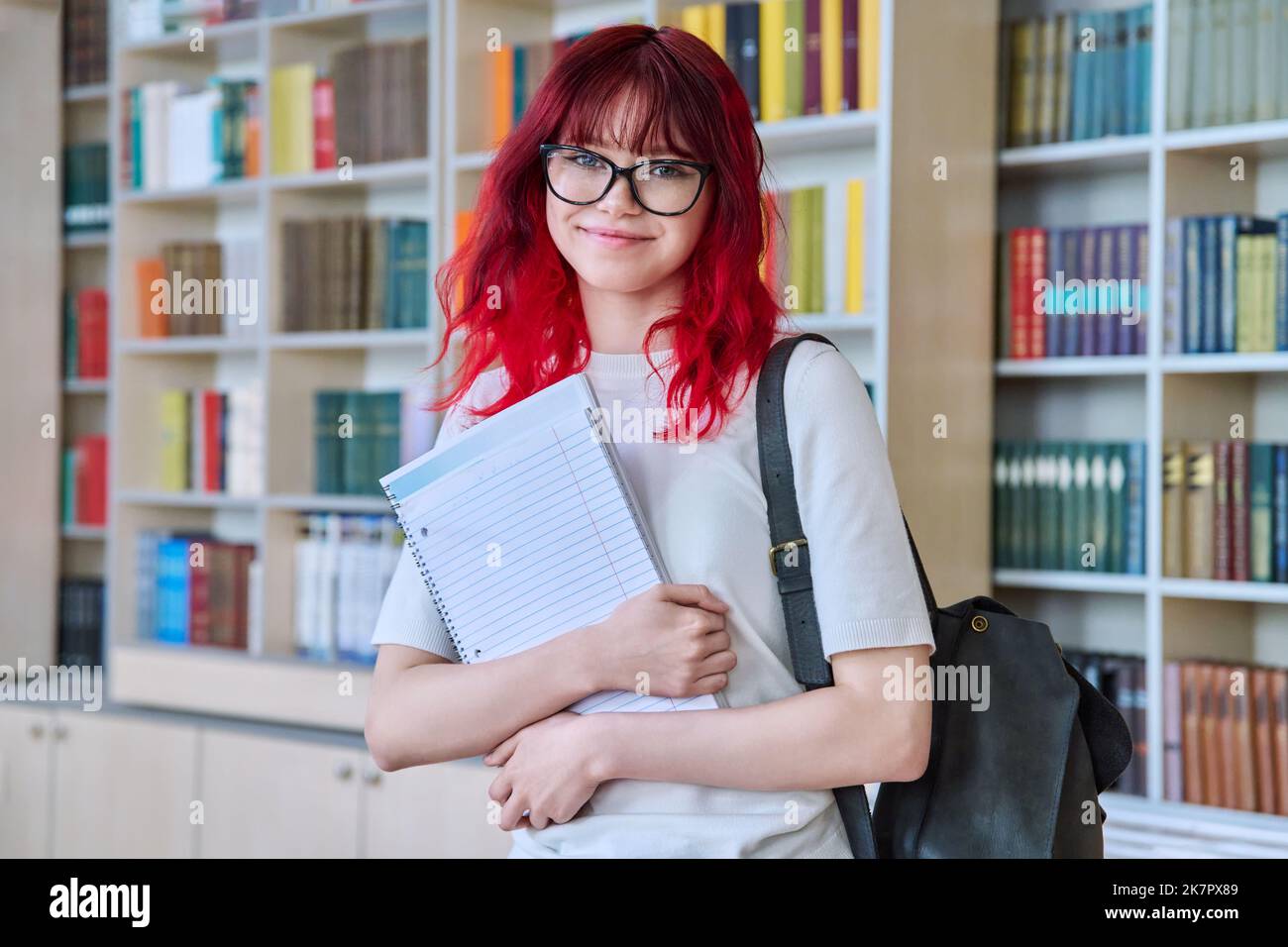 Portrait of teenage female student looking at camera in library Stock ...