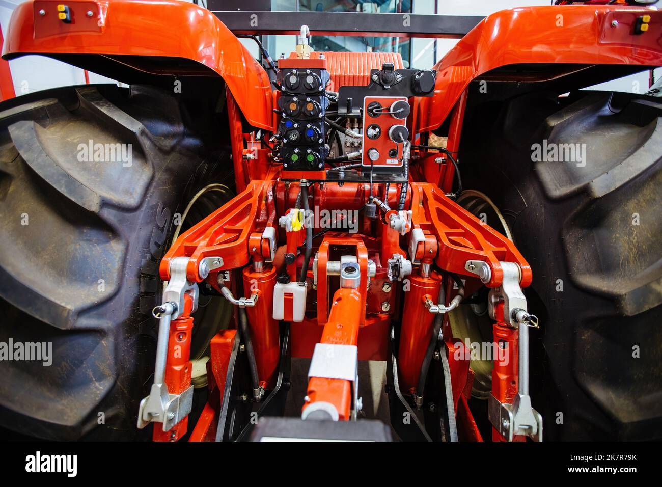 Rear view of modern agricultural tractor in hangar. Hydraulic hitch ...