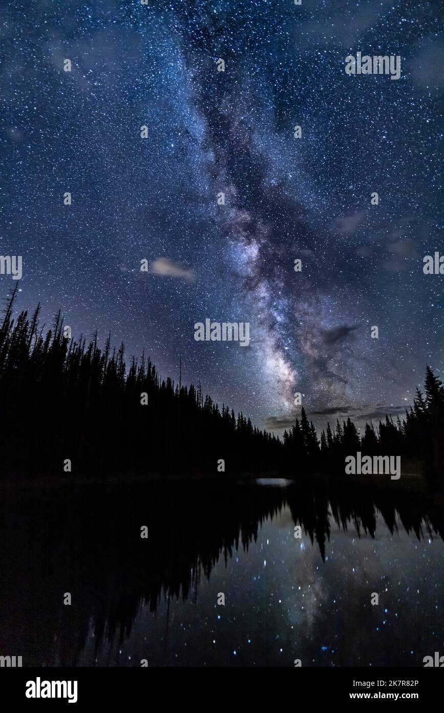 An almost vertical Milky Way is reflected in Lake Irene in Rocky Mountain National Park near Grand Lake, Colorado. Stock Photo