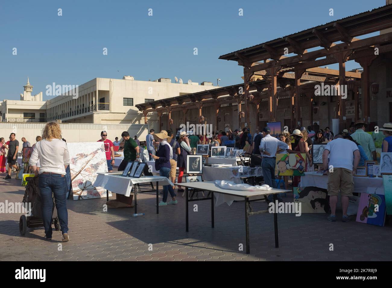 Tables with artworks from local artists at an art fair in historical Al Fahidi. Sunny outdoor event in the modern city of Dubai, United Arab Emirates. Stock Photo