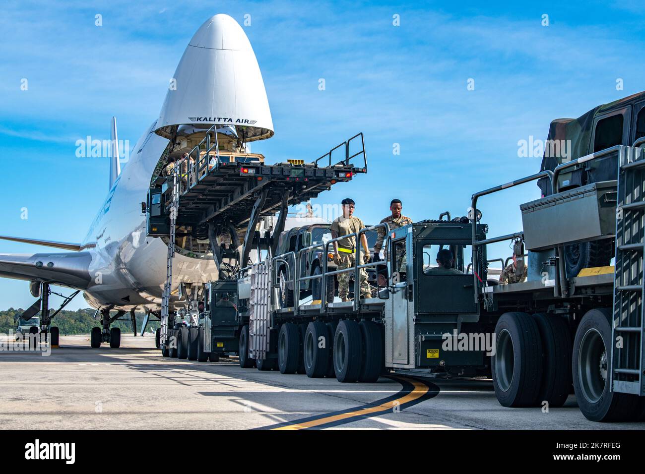 U.S. Air Force personnel load Humvees onto a Boeing 747 at Joint Base ...