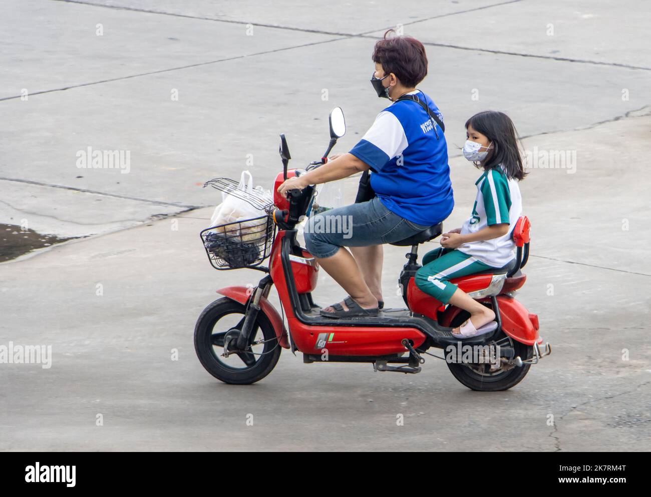 SAMUT PRAKAN, THAILAND, SEP 23 2022, A woman rides girl on a e-bike Stock Photo