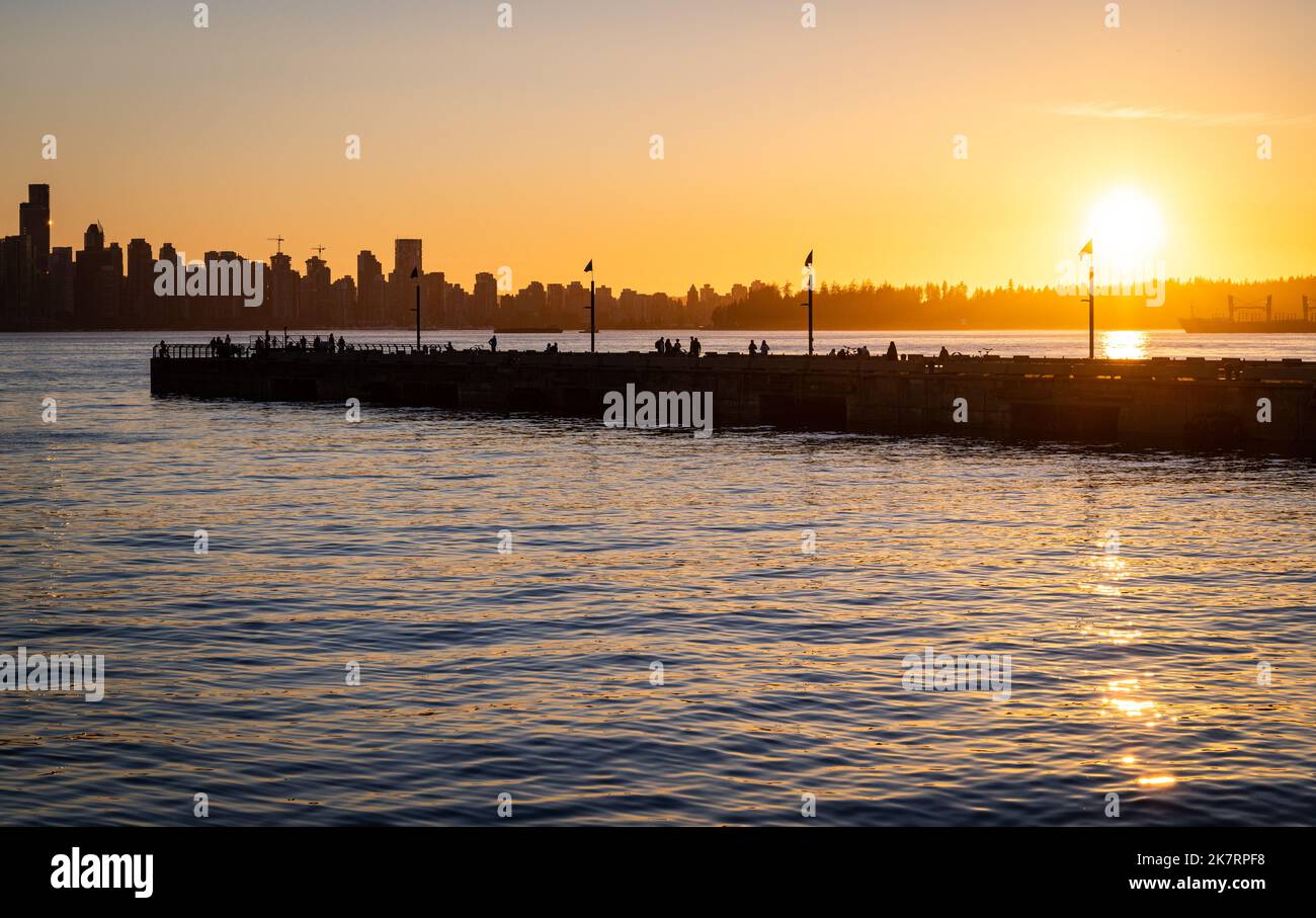 Silhouetted Lonsdale Quay in North Vancouver, B.C. Canada with view of downtown Vancouver in the background at sunset. Stock Photo