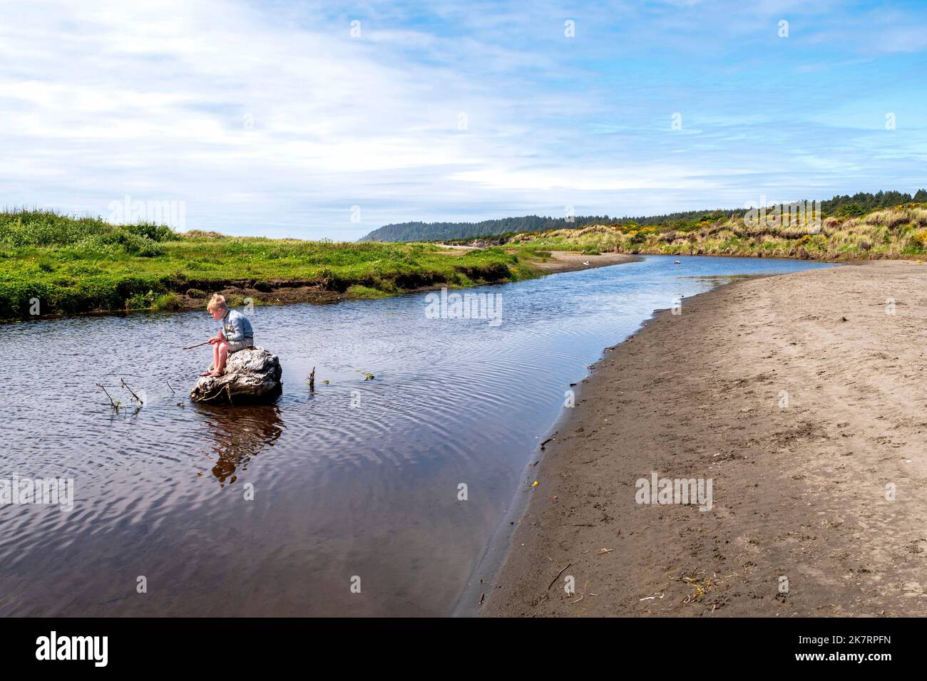 Teenage boy fishing in river at sunset, Washington, USA stock photo