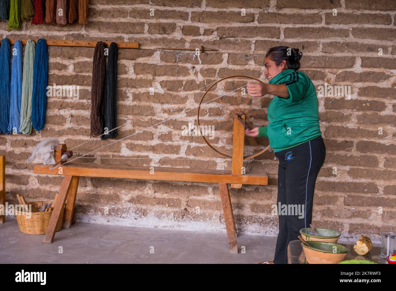 A weaver is explaining the spinning of the wool at her home in Teotitlan del Valle, a small town in the Valles Centrales Region near Oaxaca, southern Stock Photo