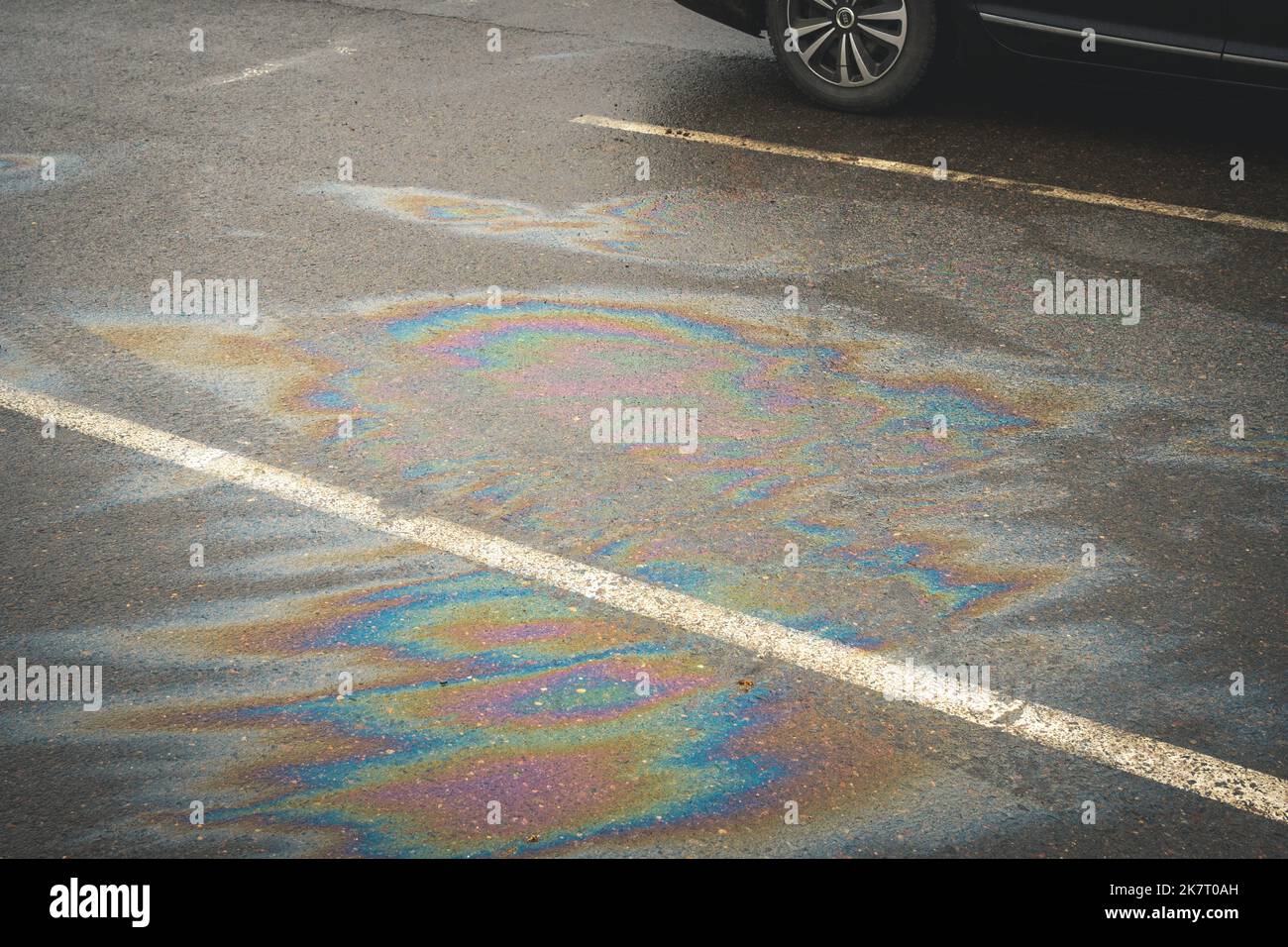 Oil spill on dark asphalt, parking lot with dividing lines Stock Photo