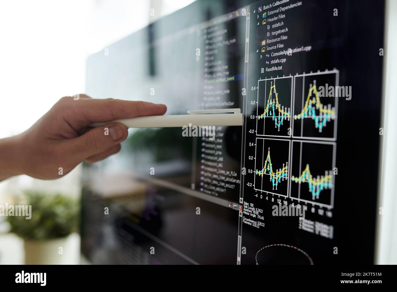 Closeup image of developer pointing at chart on computer screen Stock Photo