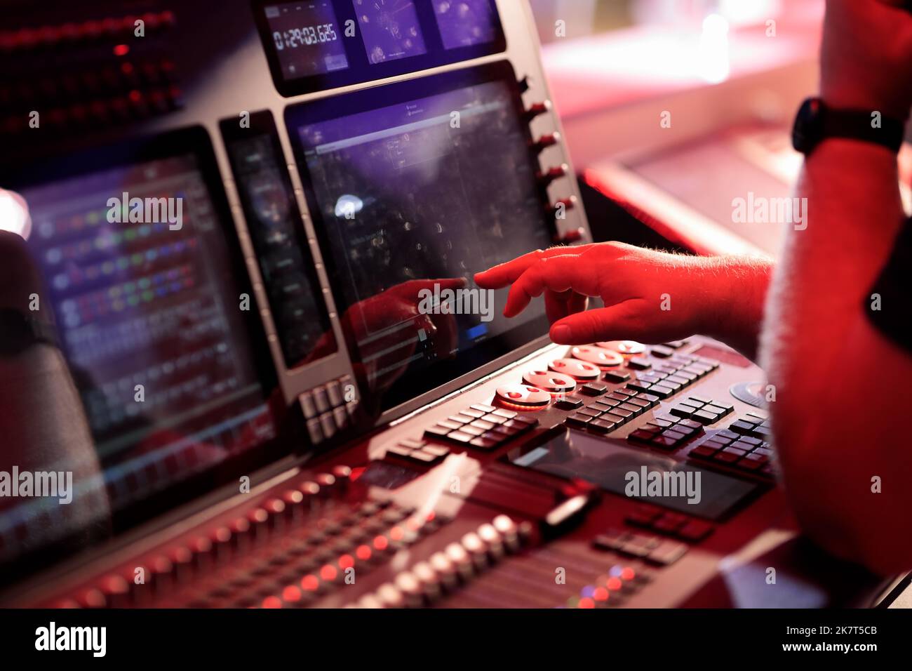 Light board operator working with control console. Selective focus