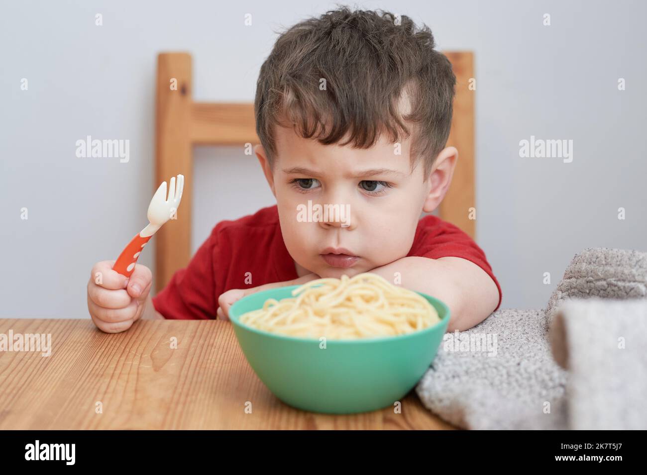 Cute boy is playing with his pasta at lunch time Stock Photo