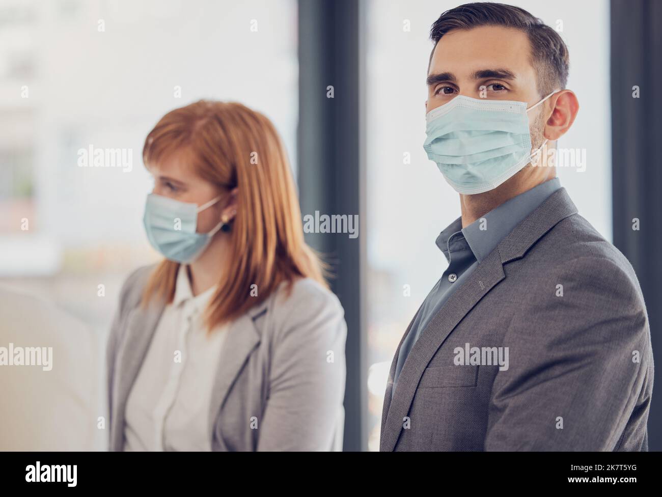 Covid, face mask and business people in office meeting after lockdown in safe, clean and healthy workplace. Leadership man portrait with vision for Stock Photo
