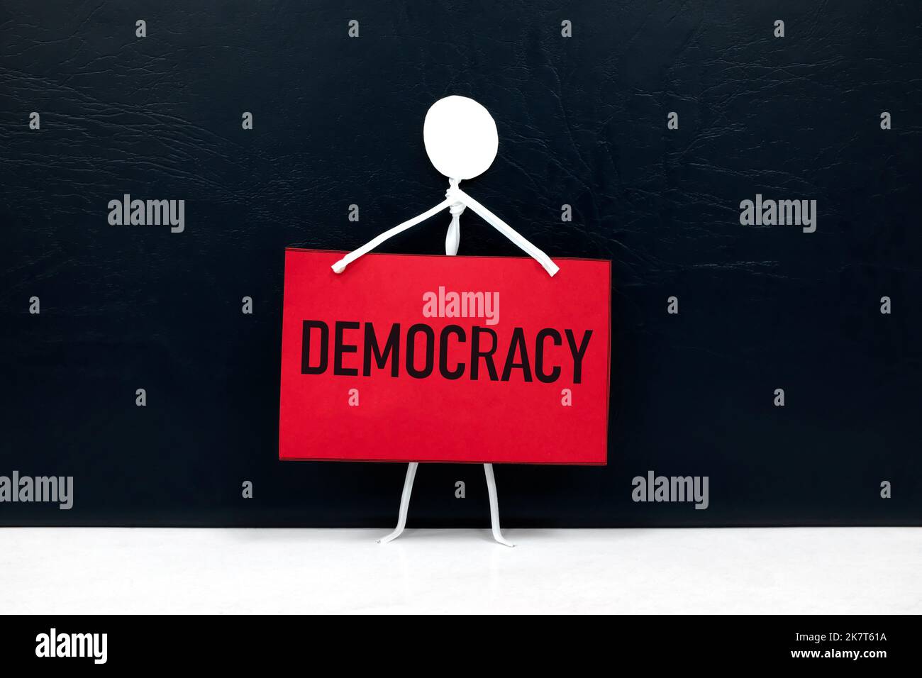 Democracy and freedom of expression concept. Human stick figure holding a red placard on dark black background Stock Photo