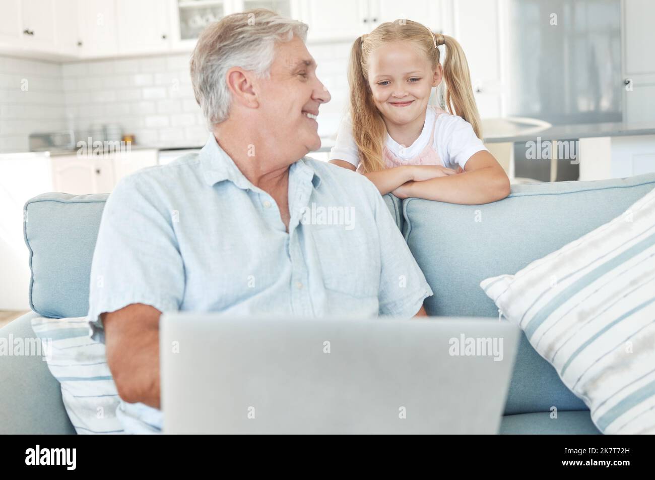 Laptop, elearning and senior family with child for online education, kids website communication and internet teaching at home on sofa. Grandfather and Stock Photo