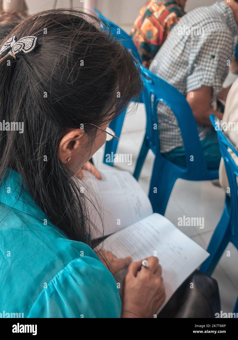 Asian woman wear glasses using pen and paper to take notes of local ...