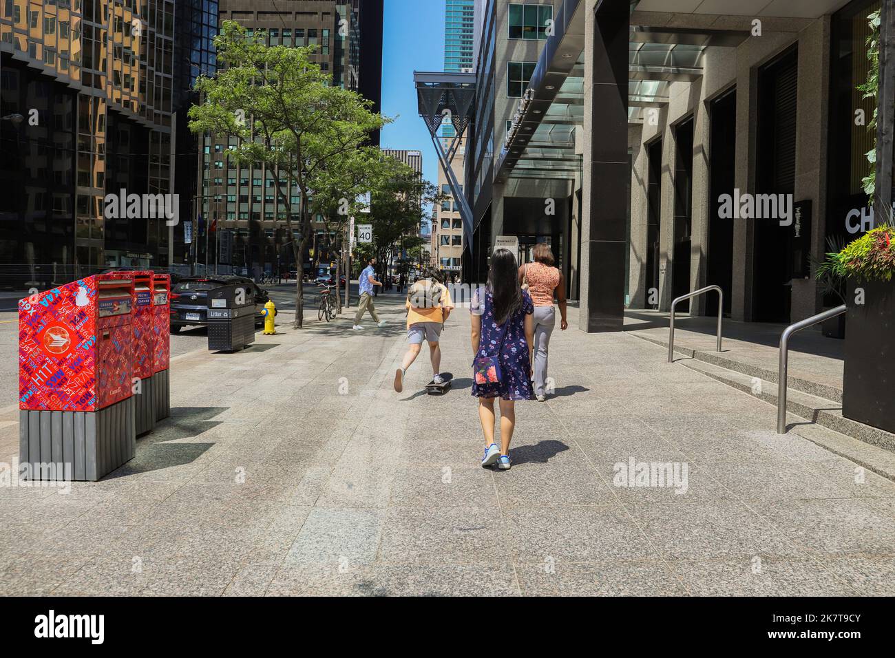 Toronto city downtown - people walking on the street. weekday working day. Summer time, blue sky background Stock Photo