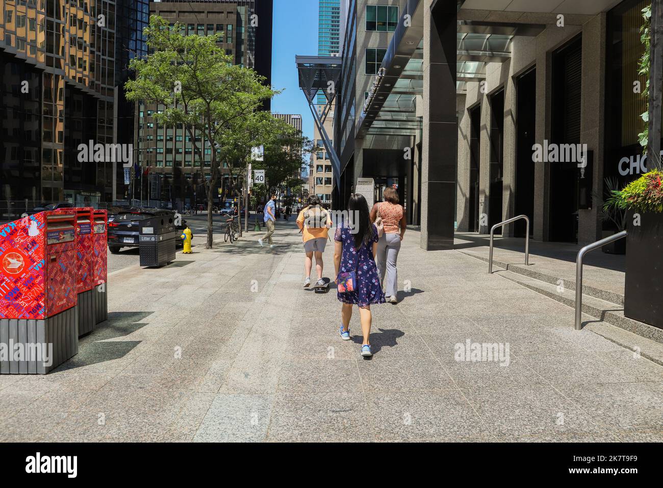 Toronto city downtown - people walking on the street. weekday working day. Summer time, blue sky background Stock Photo