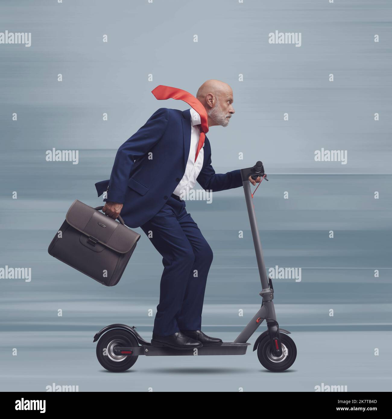 Corporate businessman riding a fast eco-friendly electric scooter, smart mobility concept Stock Photo