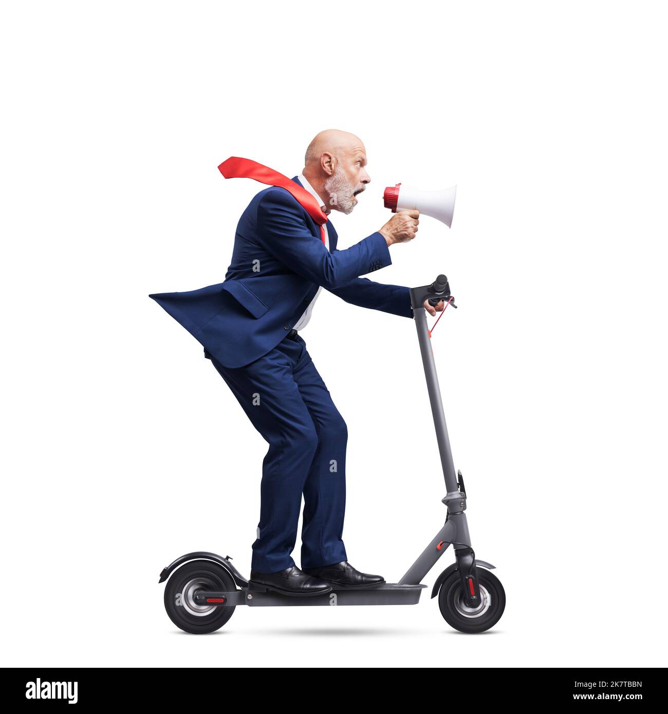 Business executive shouting through a megaphone and riding an electric scooter, isolated on white background Stock Photo