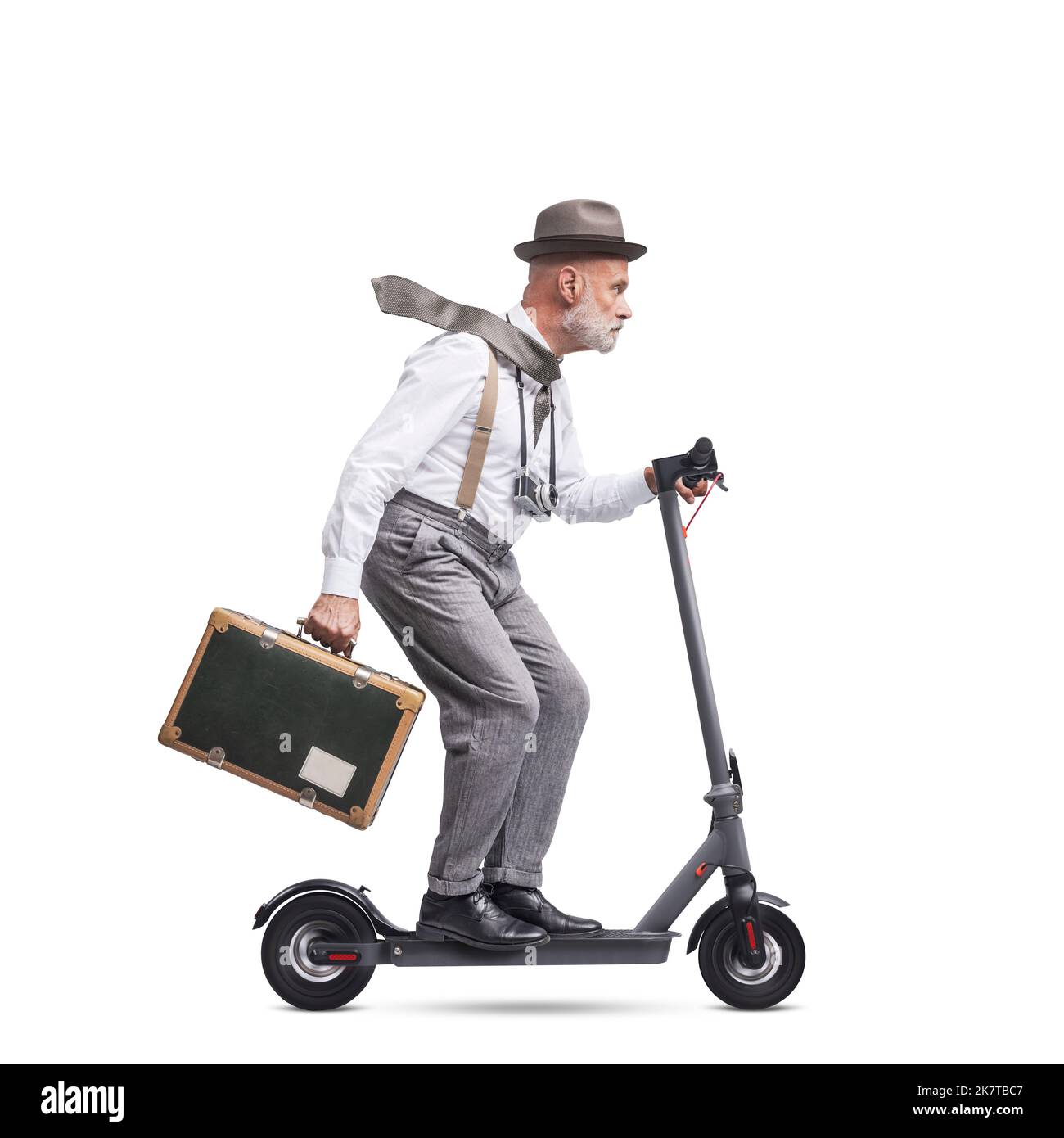 Vintage style traveler and photographer carrying a suitcase and riding an electric scooter, isolated on white background Stock Photo