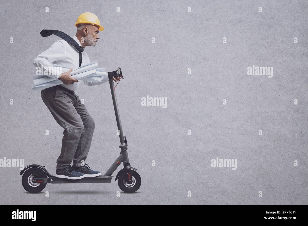 Fast engineer with safety helmet riding an electric scooter, blank copy ...