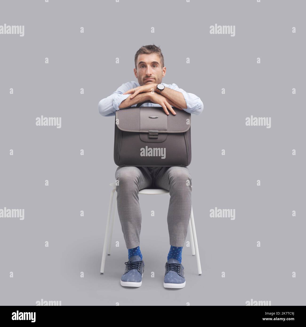 Bored man sitting on a chair and waiting for a meeting or a job interview Stock Photo